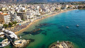 A coastal cityscape with a beach, buildings, and mountains in the background. - Solena - Garden Escape with Views near Chania (Tsikalaria)