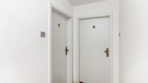 Dos puertas blancas con los números 16 y 17, cada una con cerradura y manija.