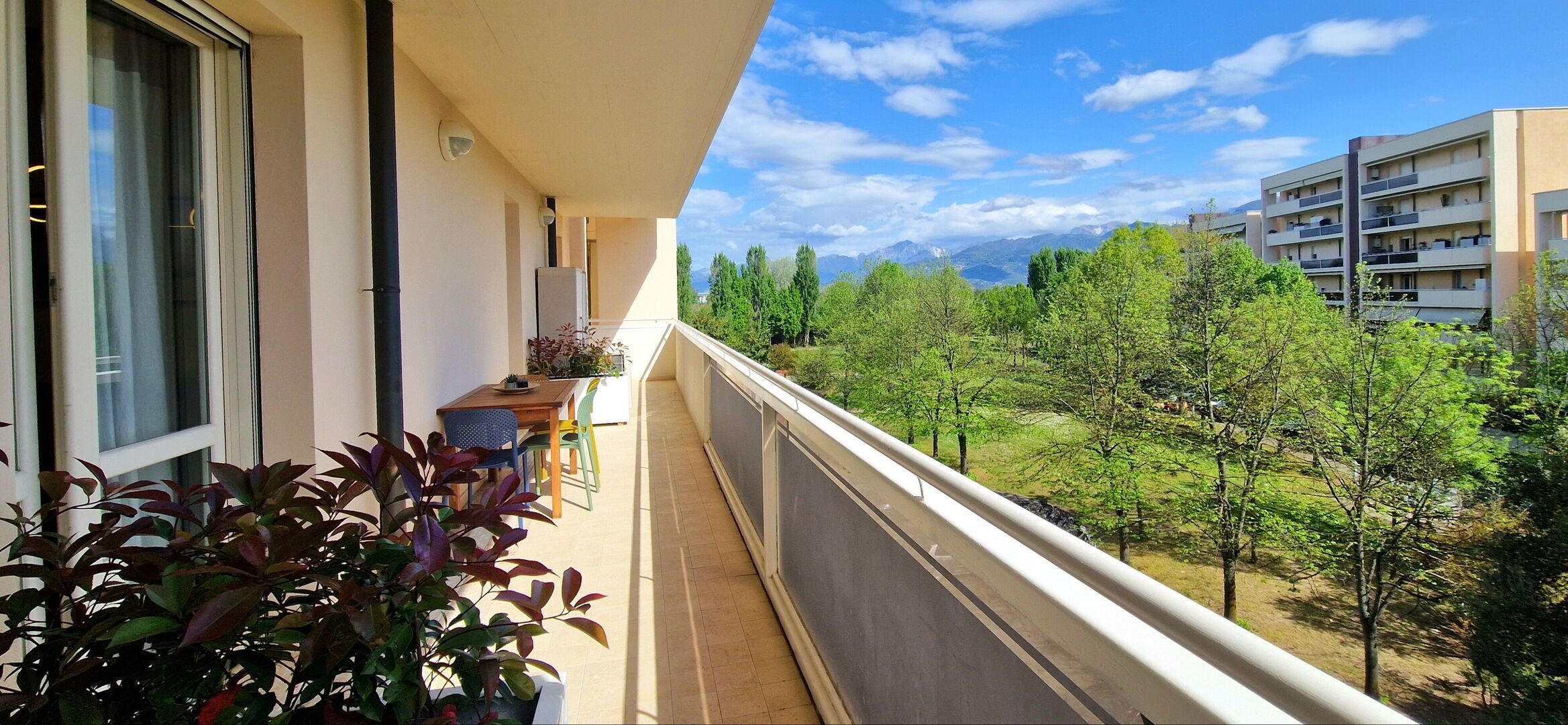 Un balcone con vista su un paesaggio verde e montagne lontane.