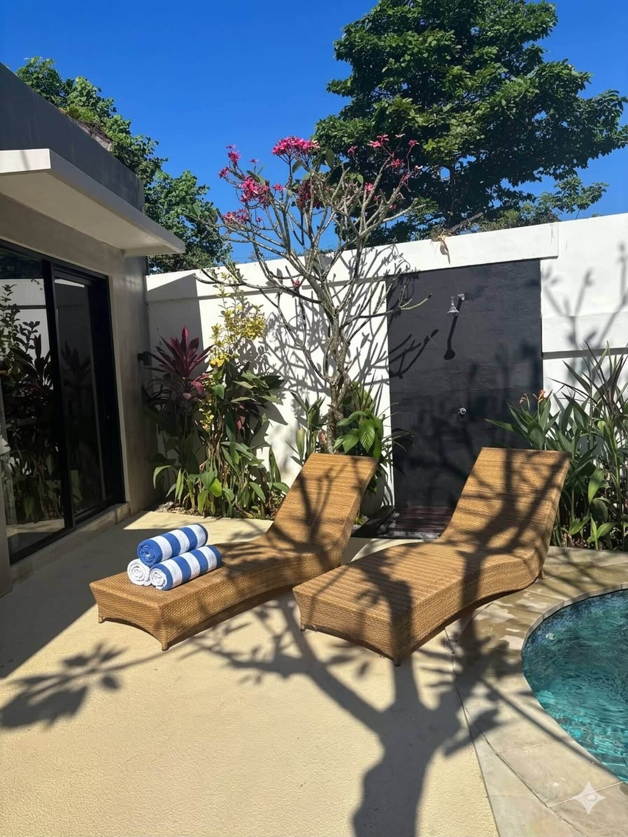 A modern outdoor pool area with lounge chairs and a small pool.