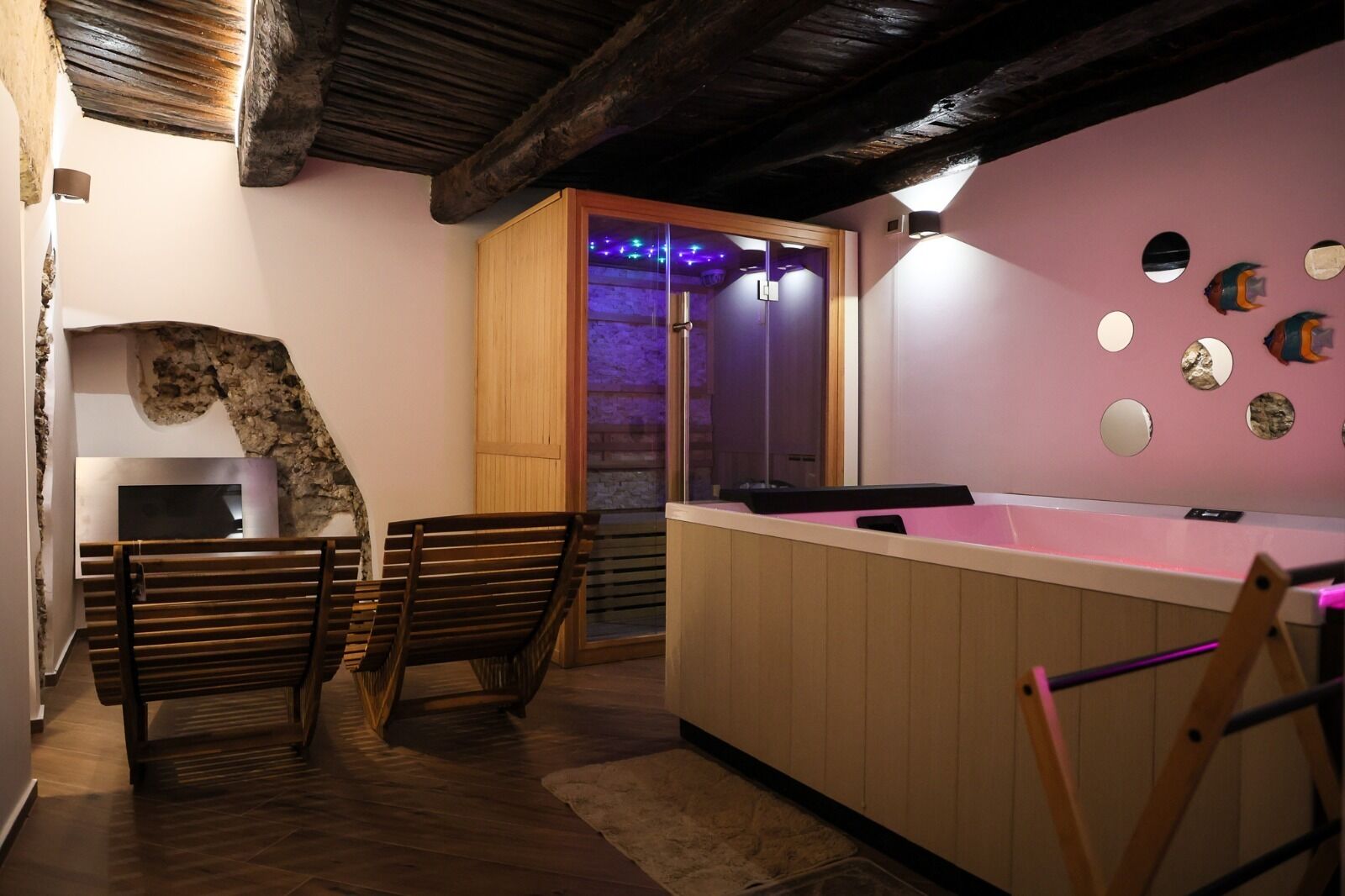 Une pièce comprenant un banc en bois, une petite table, un meuble en bois et un mur orné de miroirs ronds.