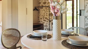 A dining area with a round table, chairs, and a vase with flowers. - Baglio Capo  (siculiana)