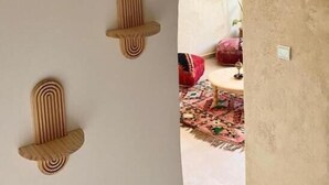 An interior corridor with a beige wall, a wooden door frame, and a patterned rug. - Sines Surfmaroc (Aourir)