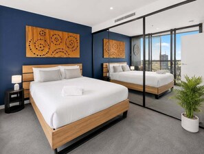 Ein modernes Hotelzimmer mit einem großen Bett, einem Nachttisch, einem Spiegel und einer Topfpflanze.