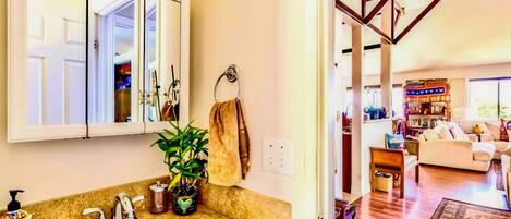 A bathroom with a sink, mirror, and towel rack.