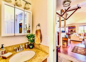 A bathroom with a sink, mirror, and towel rack. - Hale Akala - Huahine (Shared Bathroom) (Kailua-Kona)