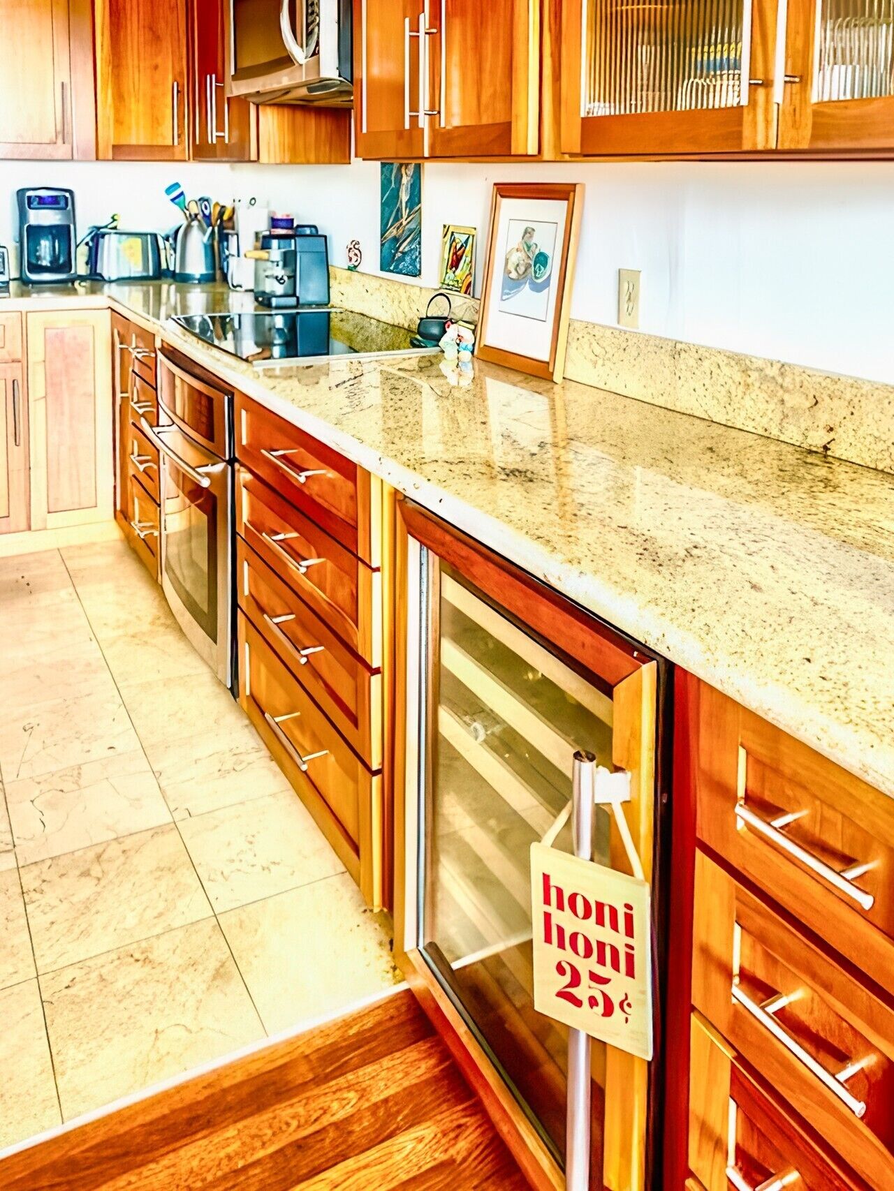 A kitchen with wooden cabinets, a granite countertop, and a stainless steel range hood.