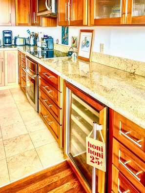 A kitchen with wooden cabinets, a granite countertop, and a stainless steel range hood.