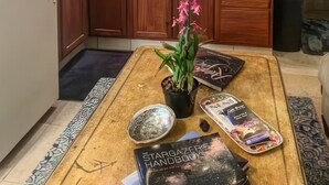 A kitchen with wooden cabinets, a refrigerator, a coffee maker, and a potted plant on a table. - Hale Akala - Surf Ohana (Kailua-Kona)