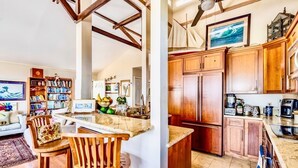 A kitchen with wooden cabinets, a marble countertop, and a built-in oven. - Hale Akala - Hanalei (Shared Bathroom) (Kailua-Kona)