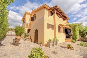 A two-story building with a tiled roof, a central door, and a small porch area. - Appartamento Delle Rose by Wonderful Italy (Budoni)