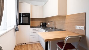 A compact kitchenette with a built-in oven, a sink, and a wooden countertop. - Haus3310 - Top 2, Balcony & Central (Bad Hofgastein)