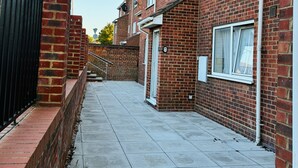 A residential street with brick houses, a gated entrance, and a clear sky. - Grays Cosy 1-Bed Apartment Sleeps 4 near Station (Grays)