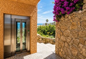 Ein Aufzug mit einer Steinwand und Blick aufs Meer.