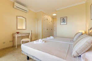 Ein Hotelzimmer mit Bett, Schreibtisch, Stuhl, Kleiderschrank und Klimaanlage.