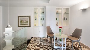 Een modern interieur met een eethoek, twee stoelen, een tafel met een vaas en een vloer met patroon.