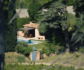 A pool area with a patio, seating, and a door leading to a covered space. - Lodge in the heart of a vineyard in Provence – Cassis and the sea are less than 10 minutes away (Roquefort-la-Bédoule)