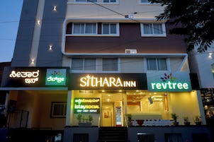 Un hotel con un cartel para SITHARA INN y REV TREE.