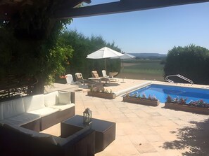 Eine Außenpatio mit Pool, Liegestühlen und einer Pergola.