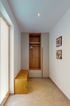 A room with a wooden bench, a wardrobe, and two wall-mounted pictures. - Chalet AlpspitzBlick – Alpine Chalet with Sauna & Garden, Garmisch-Partenkirchen (Garmisch-Partenkirchen)