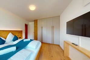 Une chambre moderne avec un lit, une armoire et un téléviseur.
