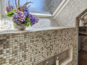 A bathroom with a tiled backsplash and a window with a flower arrangement. - Charming two-story apartment in the heart of Pont-Aven (Pont-Aven)