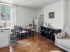 A compact living space with a dining area, a kitchenette, and a seating area with a sofa. - Charming two-story apartment in the heart of Pont-Aven (Pont-Aven)