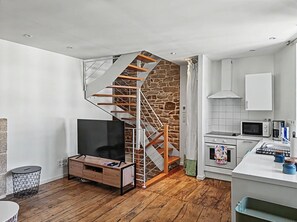 A modern kitchen with white cabinets, a microwave, a coffee maker, and a built-in oven.