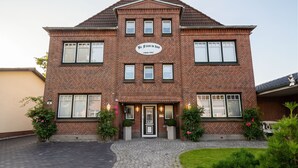 En toetages murbygning med en midterindgang, mange vinduer og et skilt, der angiver, at den blev bygget i 1942.