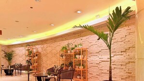 A lobby with brick walls, wooden shelving with plants, and seating areas. - Chic 1BR at JW Marriott Hotel, Dubai Marina (Dubai Marina)