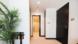 A hallway with a potted plant, a door, and a light fixture on the ceiling. - Chic 1BR at JW Marriott Hotel, Dubai Marina (Dubai Marina)