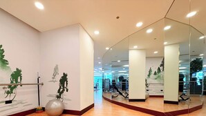 A gym with exercise equipment, a mirrored wall, and a wooden floor. - Chic 1BR at JW Marriott Hotel, Dubai Marina (Dubai Marina)