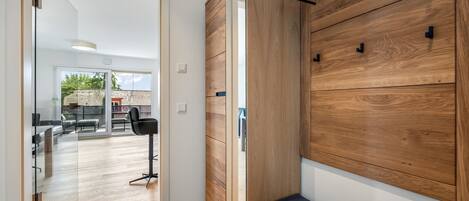 Un interior moderno con un banco de madera, un ventanal de vidrio a un patio y un diseño minimalista.