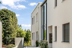 A modern building with large windows and a flat facade, surrounded by greenery. - "Berg und See" Vacation Rental - Enjoy a Modern Apartment with Panoramic Views of Lake Constance (Lindau (Bodensee))