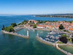 A coastal town with a marina, historic buildings, and a prominent tower. - "Berg und See" Vacation Rental - Enjoy a Modern Apartment with Panoramic Views of Lake Constance (Lindau (Bodensee))