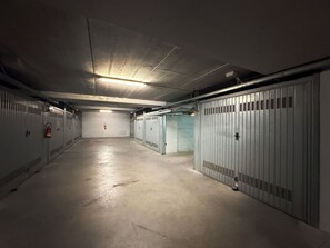 Ein langer Gang mit Schließfächern an beiden Seiten, einem Feuerlöscher links und einem Feuermelder rechts.