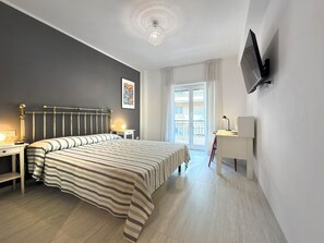 A hotel room with a bed, bedside tables, a desk, a television, and a window with curtains. - 3Bed Flat Priv Parking Metro 4min Walk (Roma)