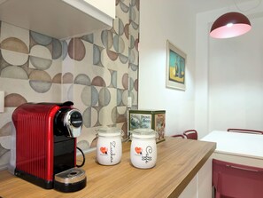 A kitchen area with a red coffee machine, two jars labeled 'Zucchero,' and a box of biscotti. - 3Bed Flat Priv Parking Metro 4min Walk (Roma)