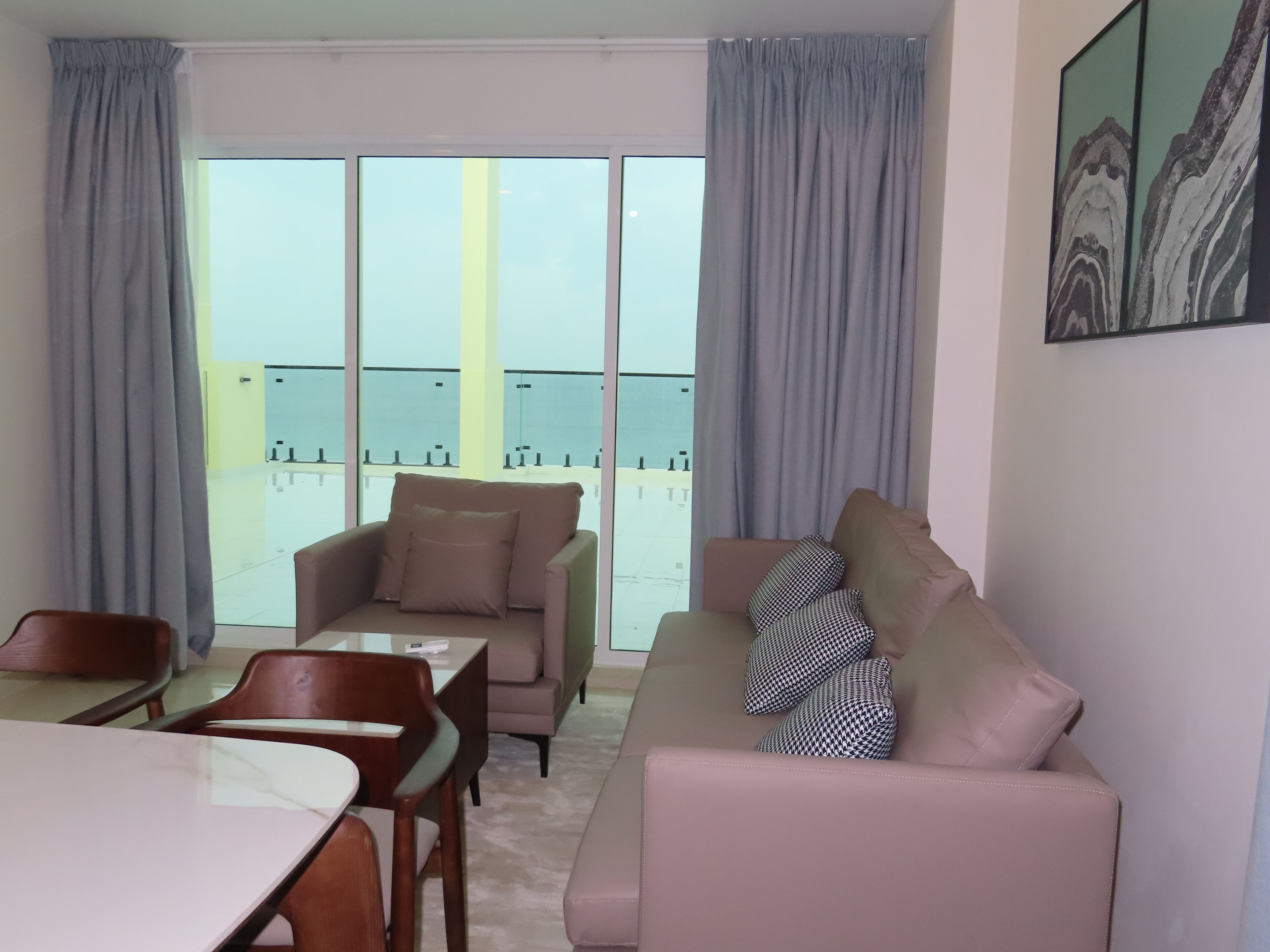 Ein modernes Wohnzimmer mit Sofa, Sessel und Esstisch.