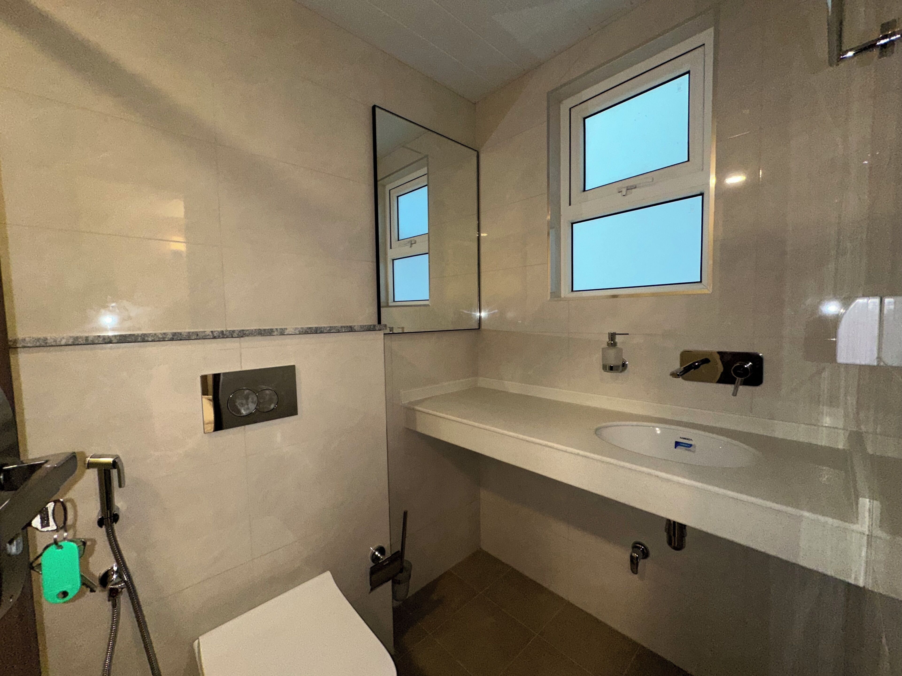 A bathroom with a white sink, a mirror, a towel rack, and a shower.