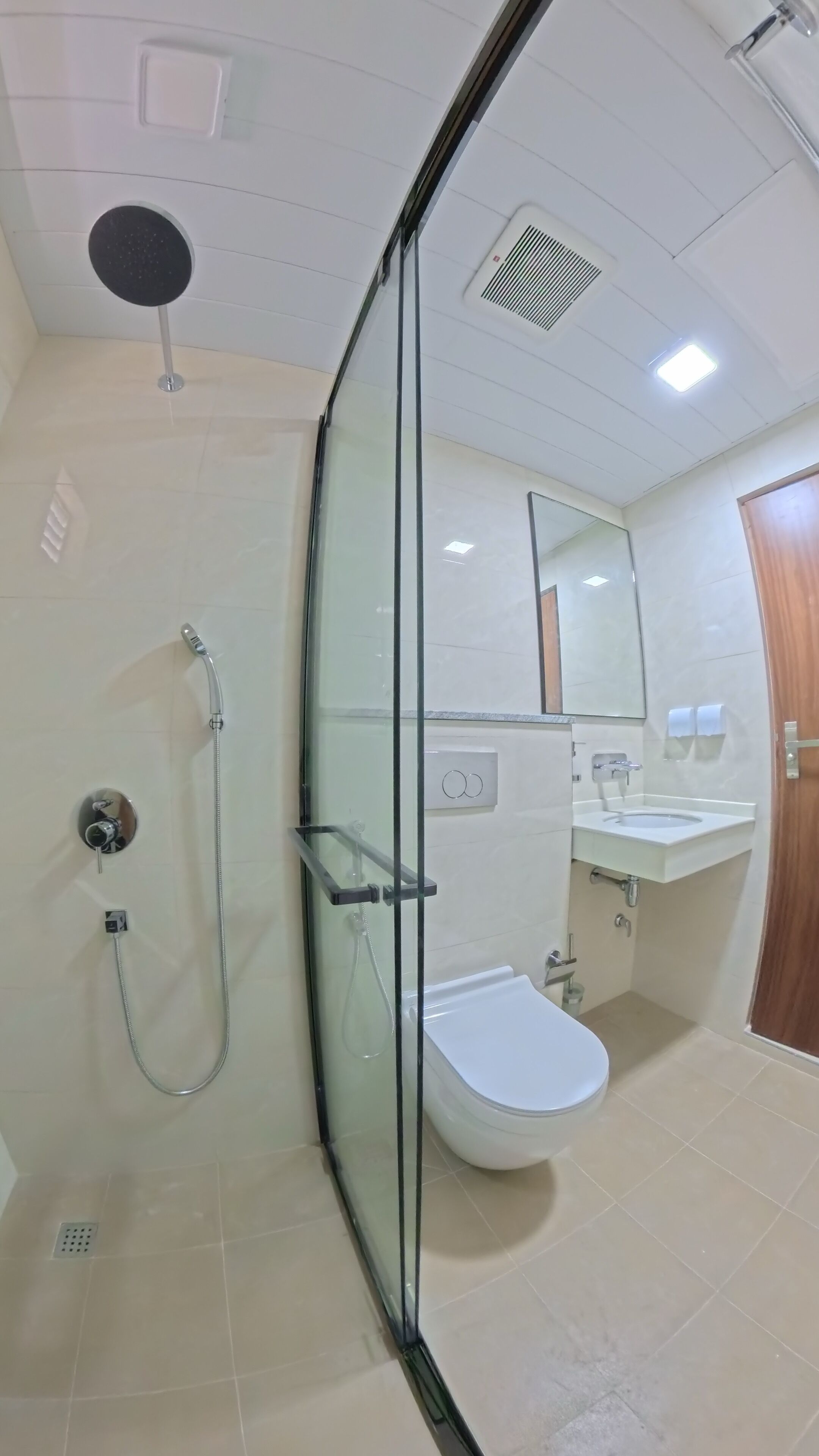 Un baño moderno con ducha de vidrio, inodoro y lavamanos.