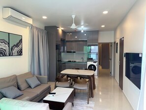 Una sala moderna con un sofá, una mesa de centro y un comedor con sillas.