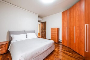 A bedroom with a bed, wooden wardrobe, and a nightstand. - Red Circuit (Fiorano Modenese)