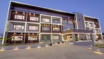 A multi-story hotel with a modern design, featuring balconies and large windows.