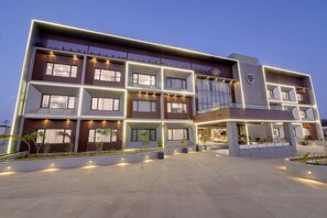 A multi-story hotel with a modern design, featuring balconies and large windows.