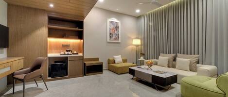 A modern living room with a sofa, armchairs, a coffee table, and a television.