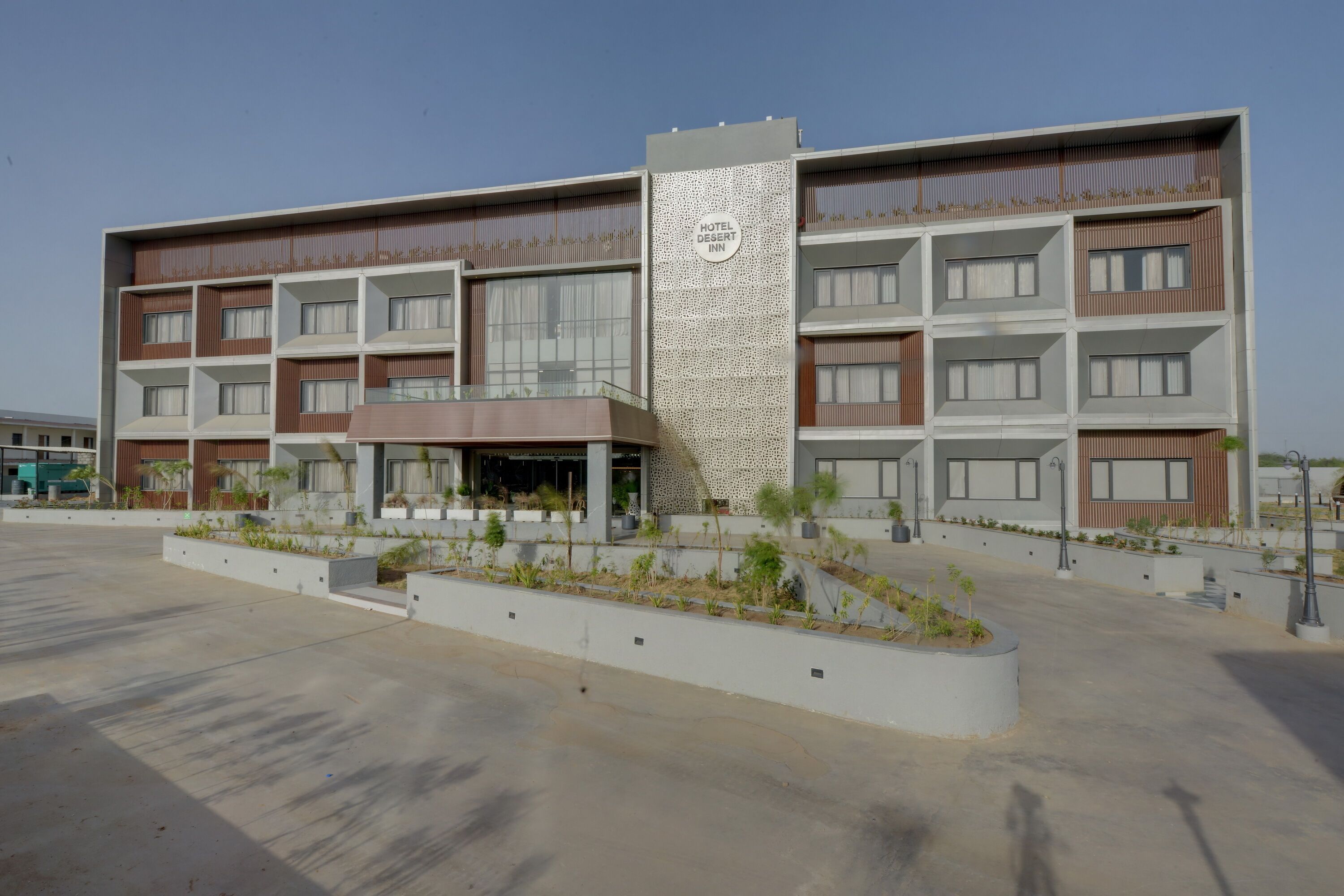A multi-story hotel with a modern design, featuring a central vertical structure and balconies on each floor.