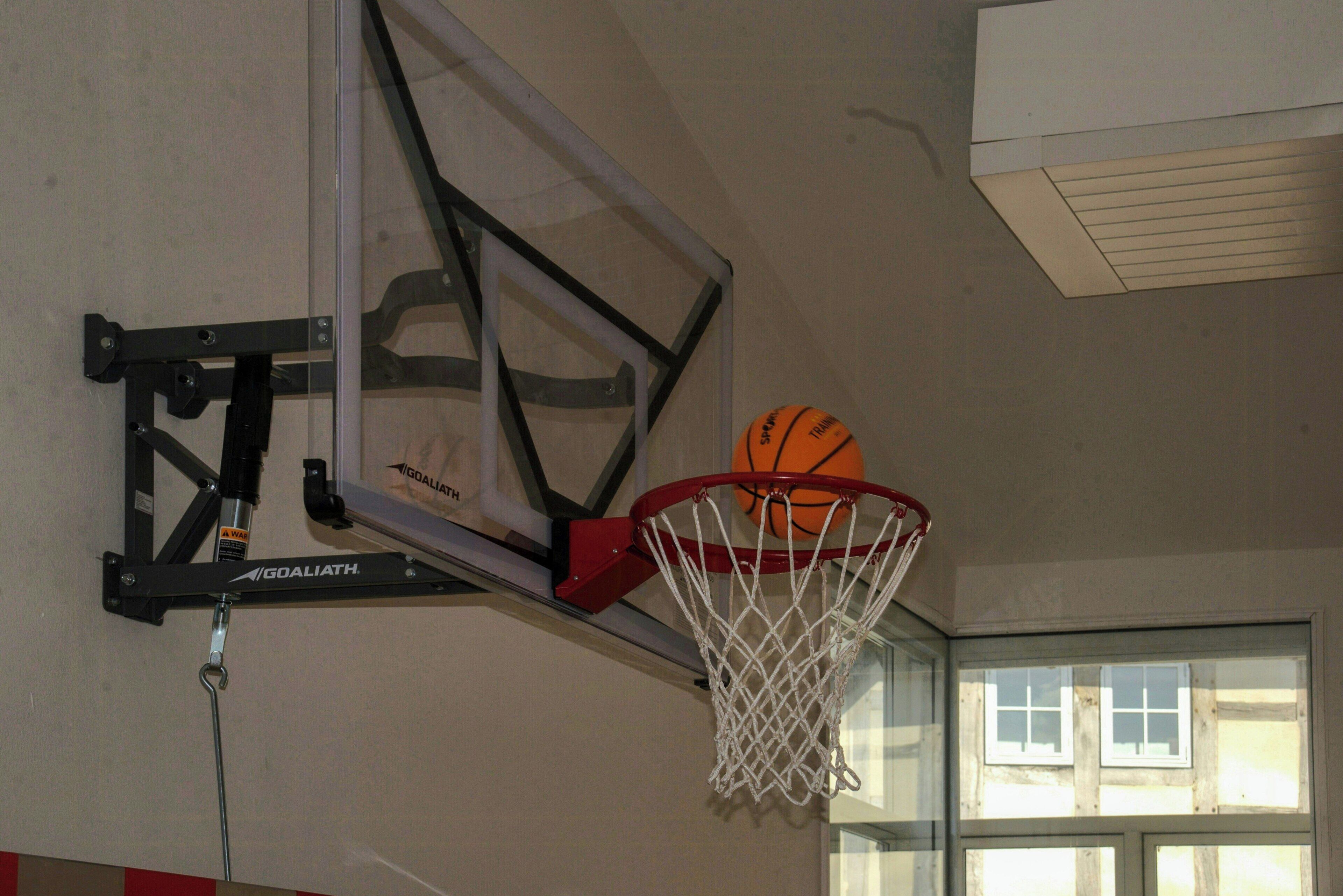 Een basketbalring met net, bevestigd aan een muur met een metalen frame.