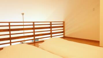 A room with two beds, a wooden headboard, and a single light fixture.
