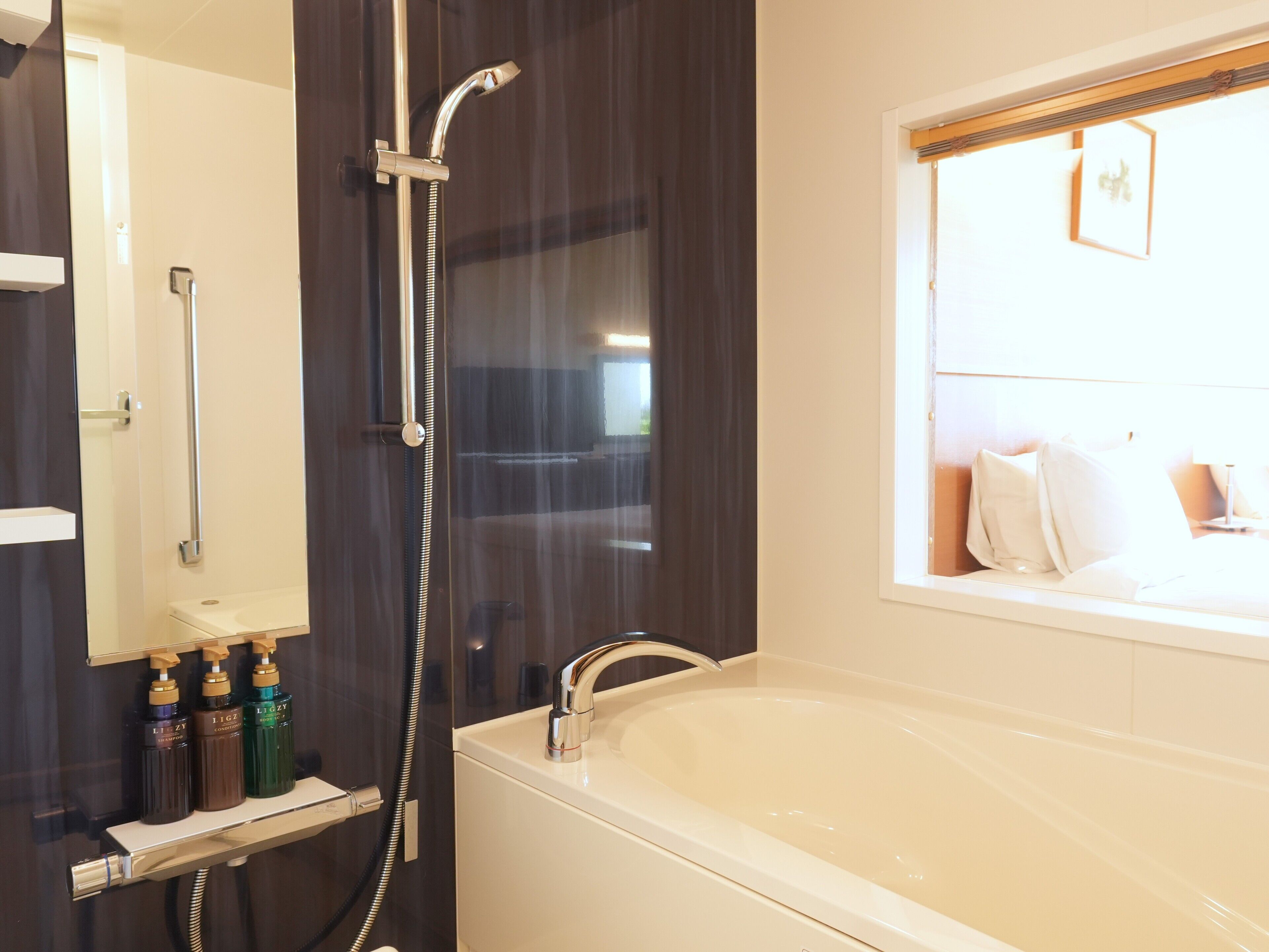 A bathroom with a bathtub, a shower, and a vanity with toiletries.